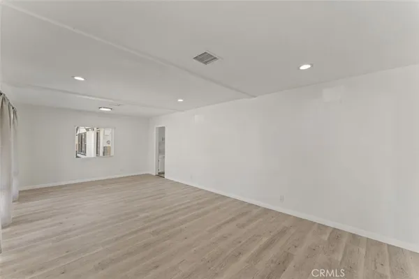 an empty room with wooden floor fireplace and cabinet