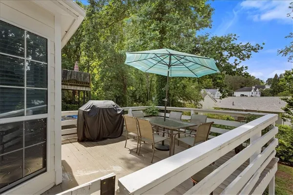 a view of a patio with couches table and chairs under an umbrella