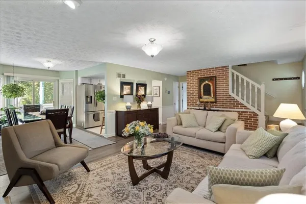 a living room with furniture and view of kitchen