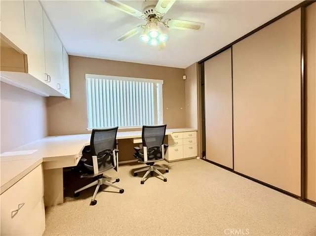 a view of a workspace with furniture and a window