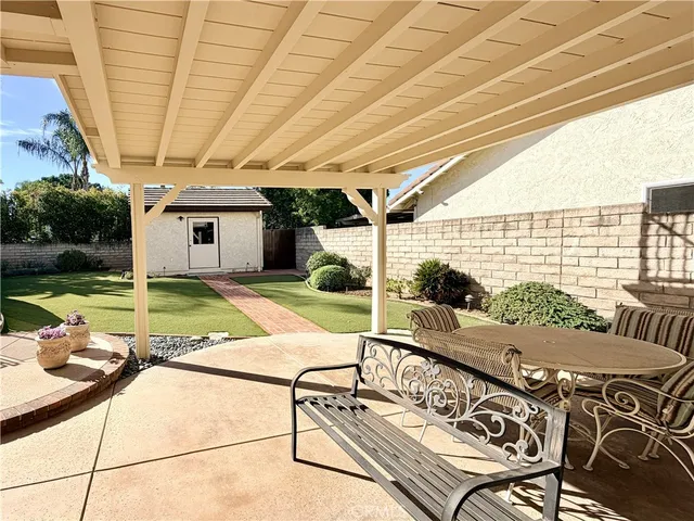 a view of a patio with table and chairs with wooden floor and fence