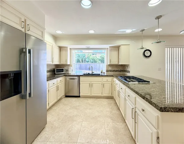 a kitchen with white cabinets stainless steel appliances and a window
