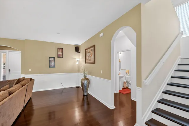 a kitchen with stainless steel appliances a table chairs refrigerator and wooden floor