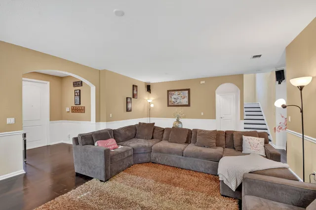 a living room with furniture and a wooden floor