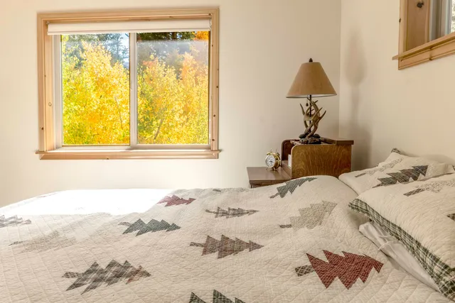 a bed sitting in a bedroom next to a window