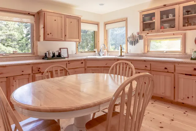 a view of a kitchen with kitchen island a sink a window and a dining table
