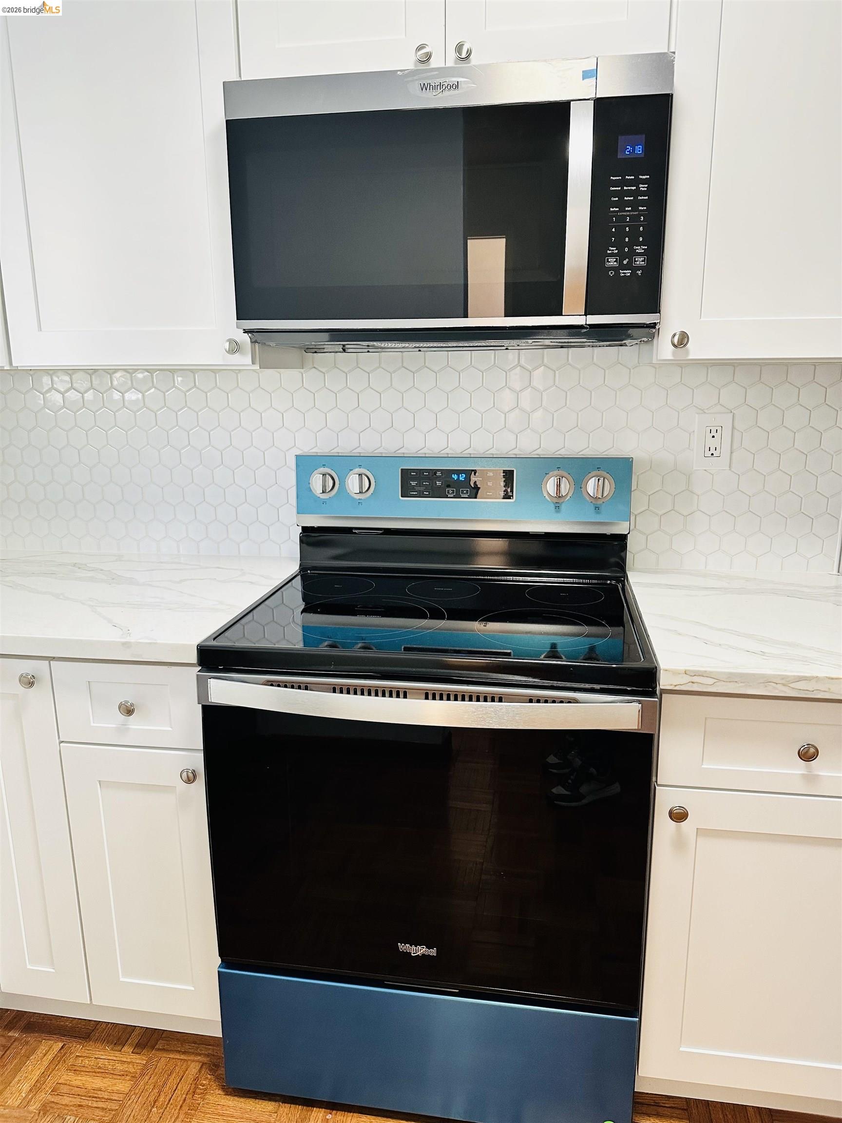 9005 Alcosta Boulevard, Unit 189 San Ramon, CA 94583 - Photo 4 of 20 Kitchen view of appliances with stainless steel finishes, decorative backsplash, white cabinetry, and light stone countertops