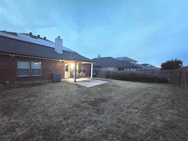 a view of a house with a yard and a large tree
