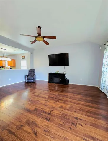 a view of a livingroom with wooden floor and a flat screen tv