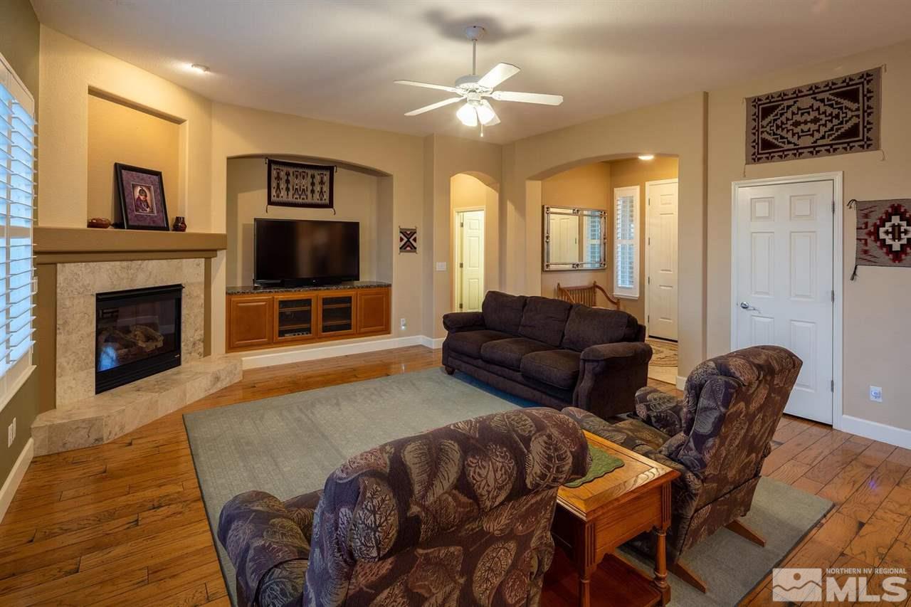 5633 North White Sands Road Reno, NV 89511 - Photo 9 of 40 a living room with furniture a flat screen tv and a fireplace