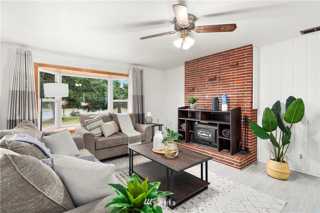 2905 Northeast 5th Place Renton, WA 98056 - Photo 14 of 36 a living room with furniture a fireplace a potted plant and a large window