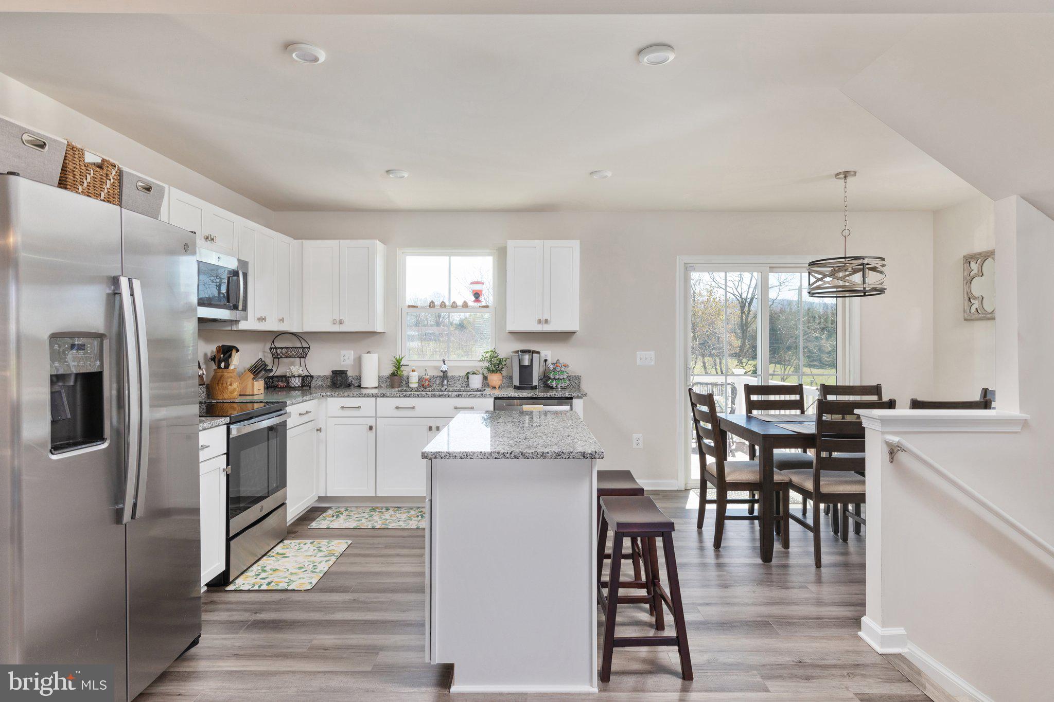 101 Williams Street Strasburg, VA 22657 - Photo 5 of 21 a kitchen with granite countertop a refrigerator a stove a sink a dining table and chairs