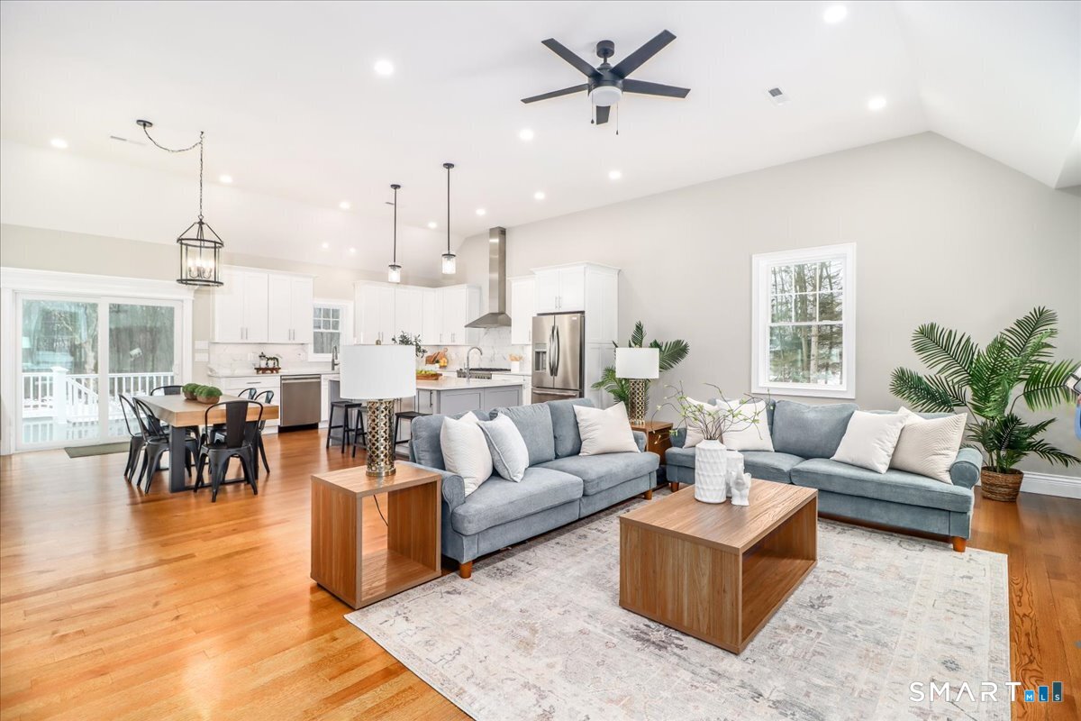a living room with furniture kitchen view and a large window