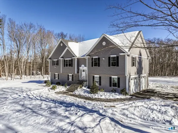 a front view of a house with a yard covered with snow in front of it