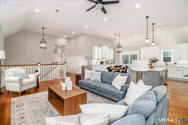 a living room with furniture kitchen view and a chandelier