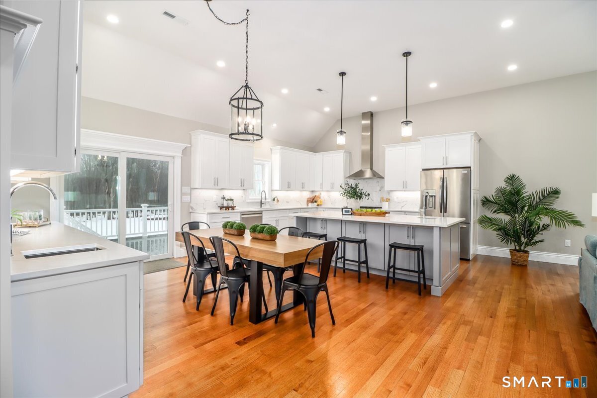 109 Codfish Hill Road Bethel, CT 06801 - Photo 28 of 43 a dining room with stainless steel appliances kitchen island granite countertop a table chairs and a wooden floor