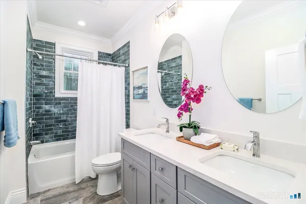 a bathroom with a double vanity sink mirror and toilet
