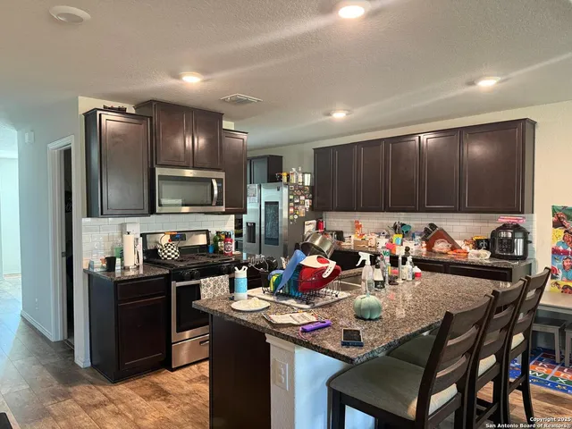 a kitchen with a cabinets appliances and a dining table