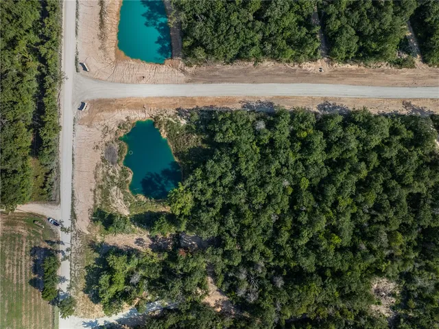 an aerial view of ocean with green space