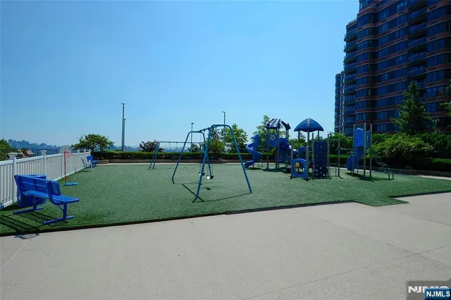a view of a park with multi story residential apartment building in the back