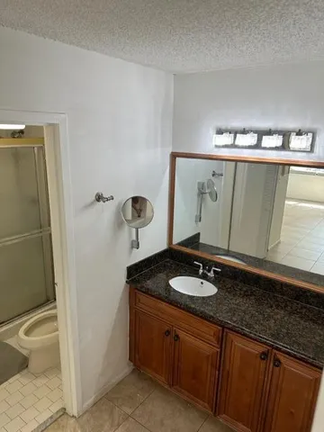 a bathroom with a granite countertop sink and a mirror