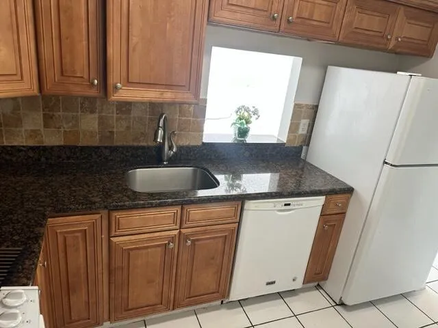 a kitchen with granite countertop white cabinets and white appliances