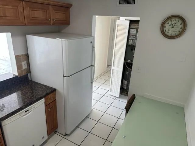 a white refrigerator freezer and a stove sitting inside of a kitchen