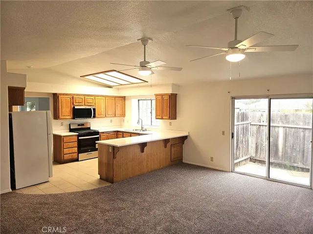 a large kitchen with cabinets a sink and stainless steel appliances