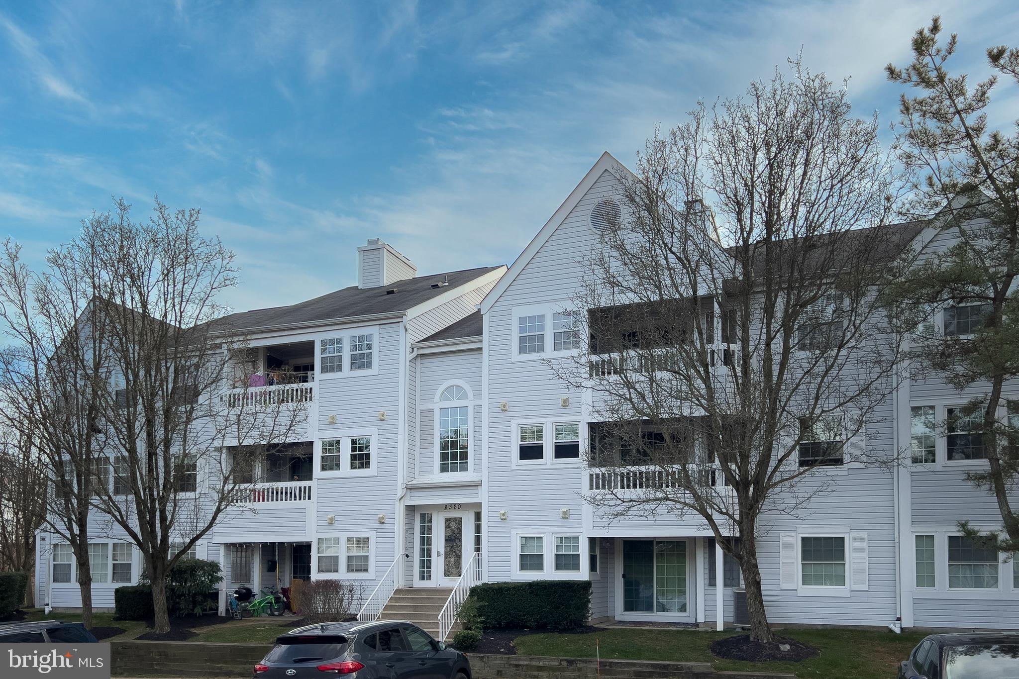 a front view of residential houses with yard and trees