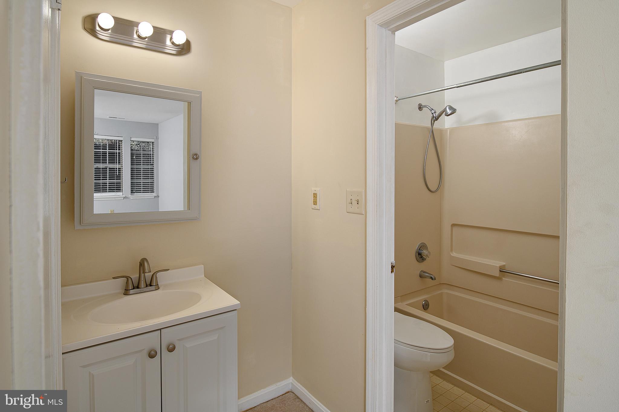 8360 Montgomery Run Road, Unit G Ellicott City, MD 21043 - Photo 15 of 20 a bathroom with a granite countertop sink toilet and shower