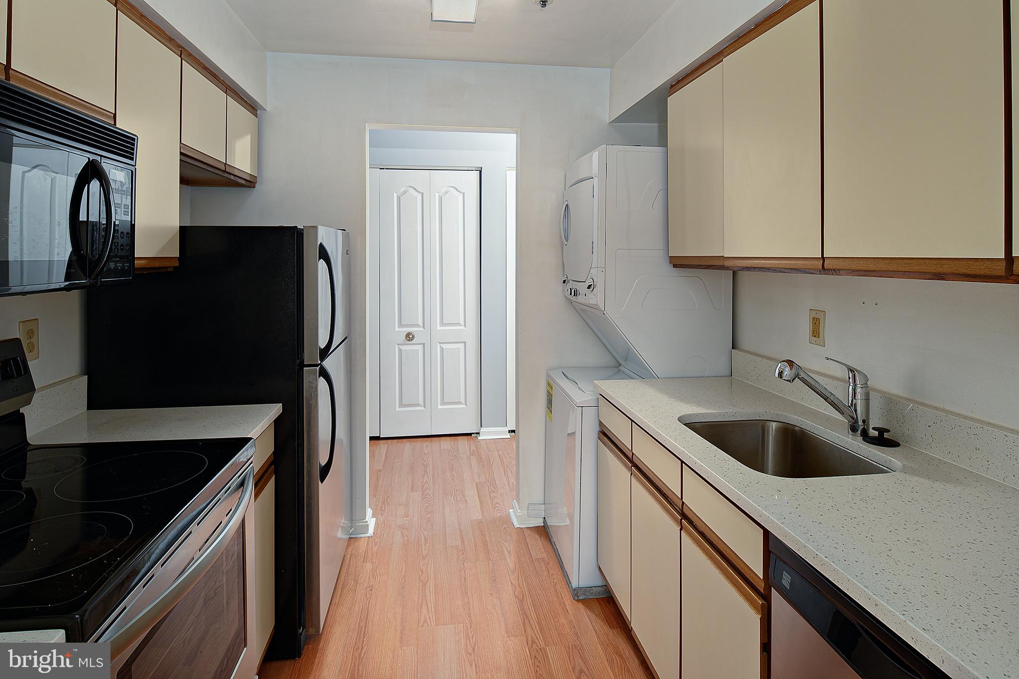 8360 Montgomery Run Road, Unit G Ellicott City, MD 21043 - Photo 7 of 20 a kitchen with stainless steel appliances granite countertop a sink stove and refrigerator