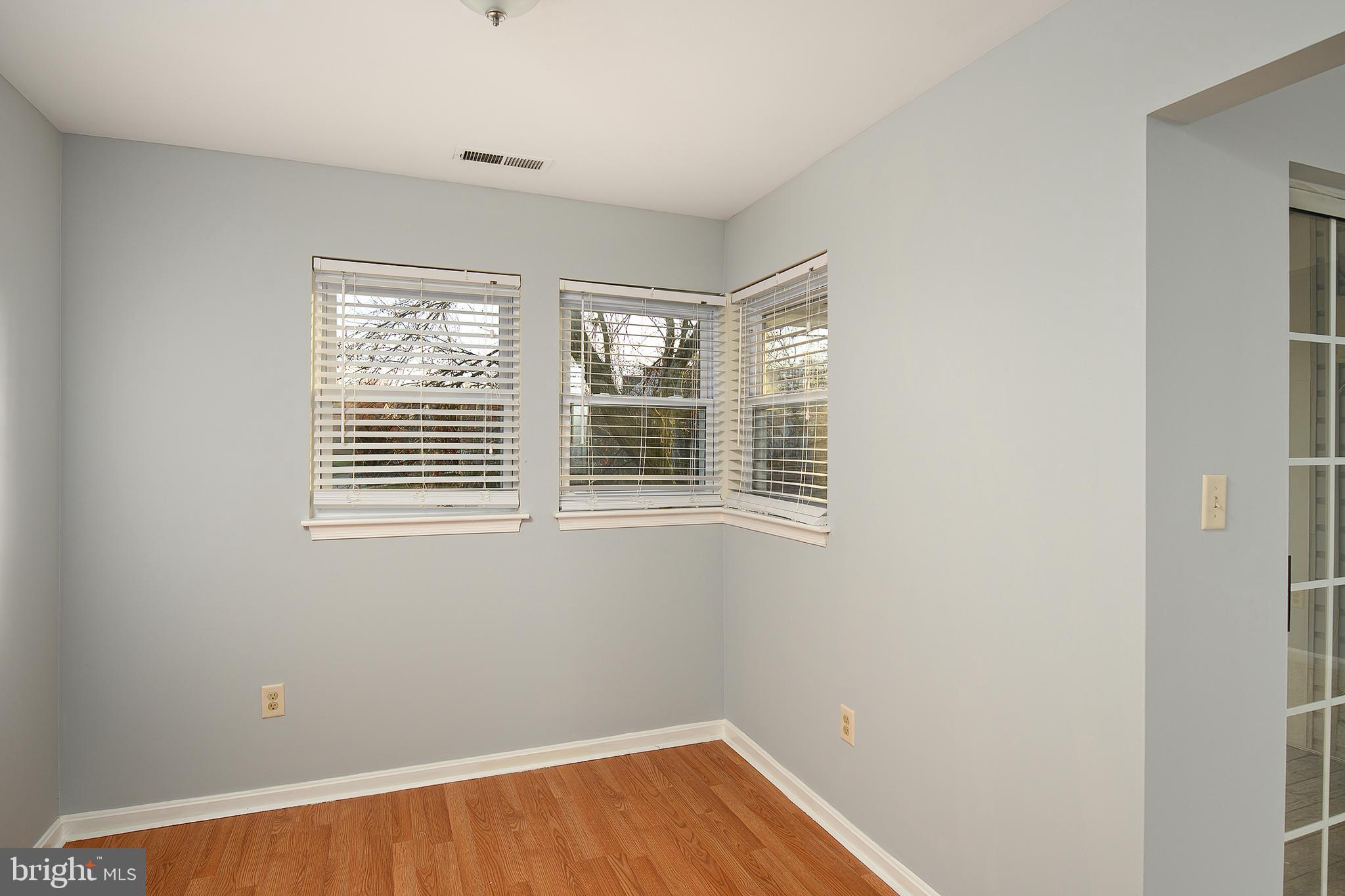 8360 Montgomery Run Road, Unit G Ellicott City, MD 21043 - Photo 10 of 20 a view of an empty room with wooden floor and a window