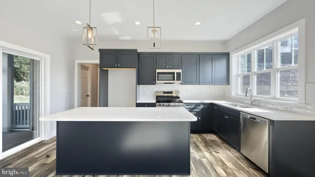 a kitchen with stainless steel appliances a sink stove and refrigerator