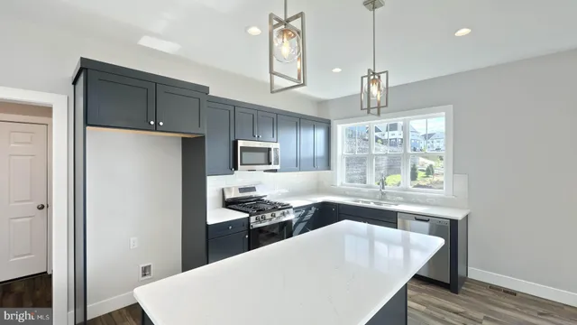 a kitchen with kitchen island a sink stove and refrigerator