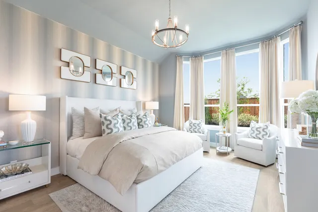 a bedroom with a large bed and a chandelier