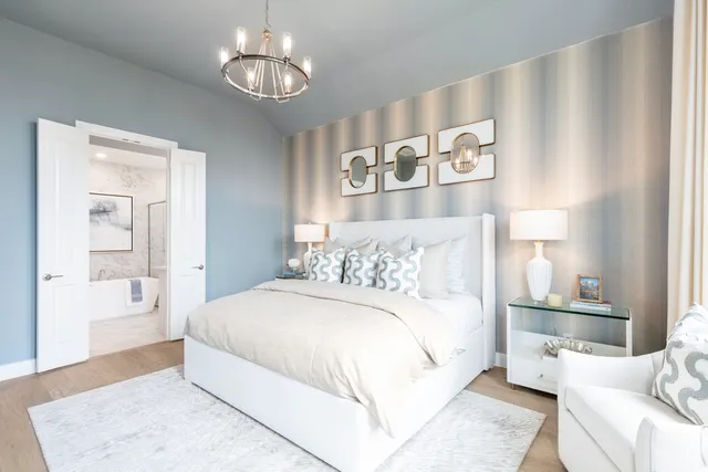 a bedroom with a large bed and a chandelier