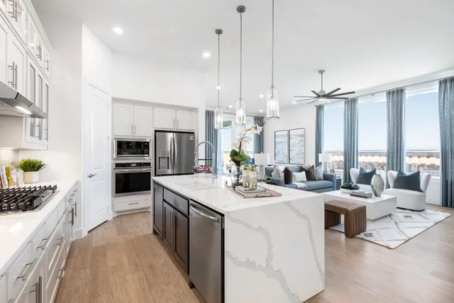 a large kitchen with kitchen island a large counter top appliances and cabinets