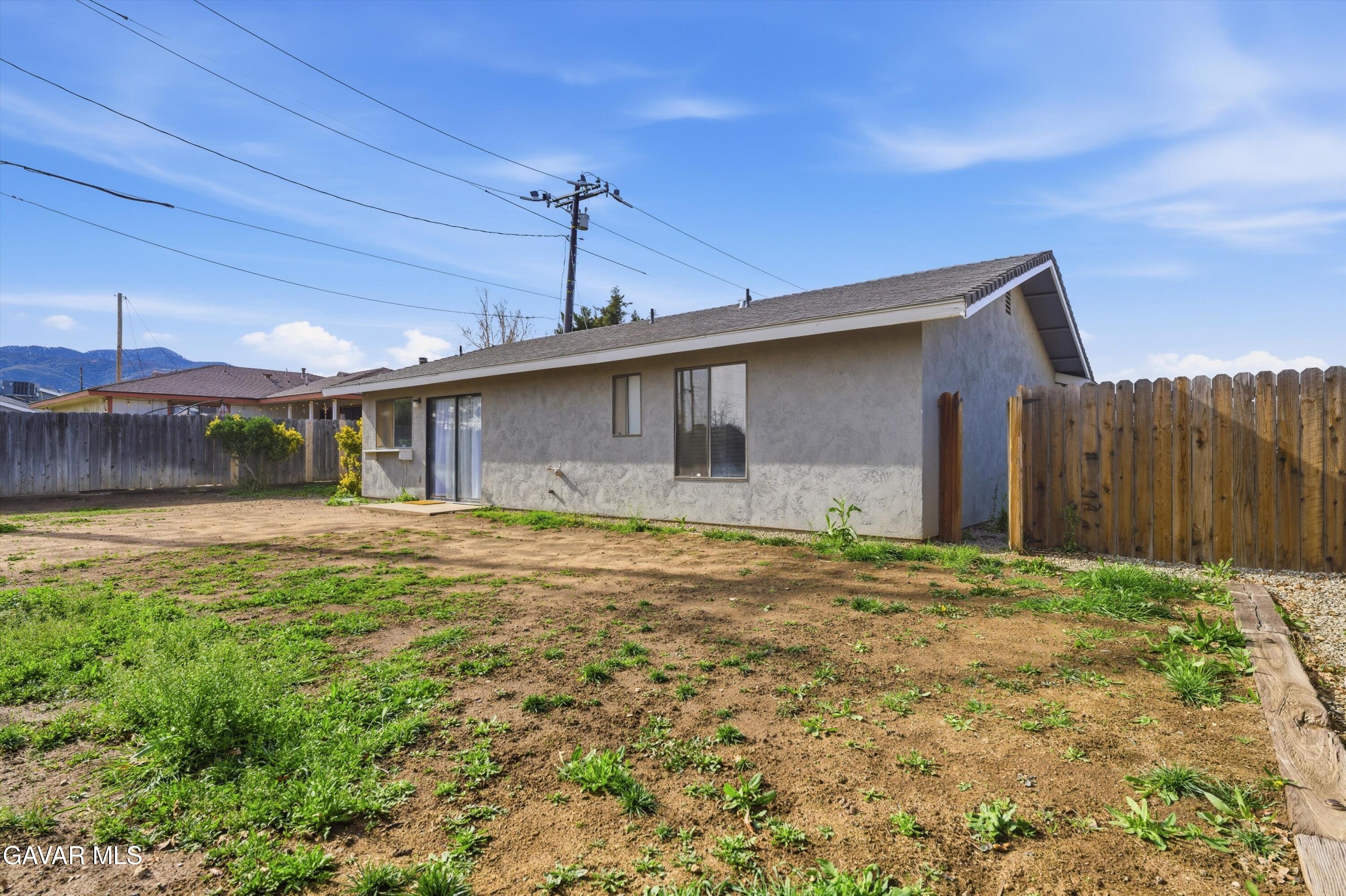 a backyard of a house with table and chairs