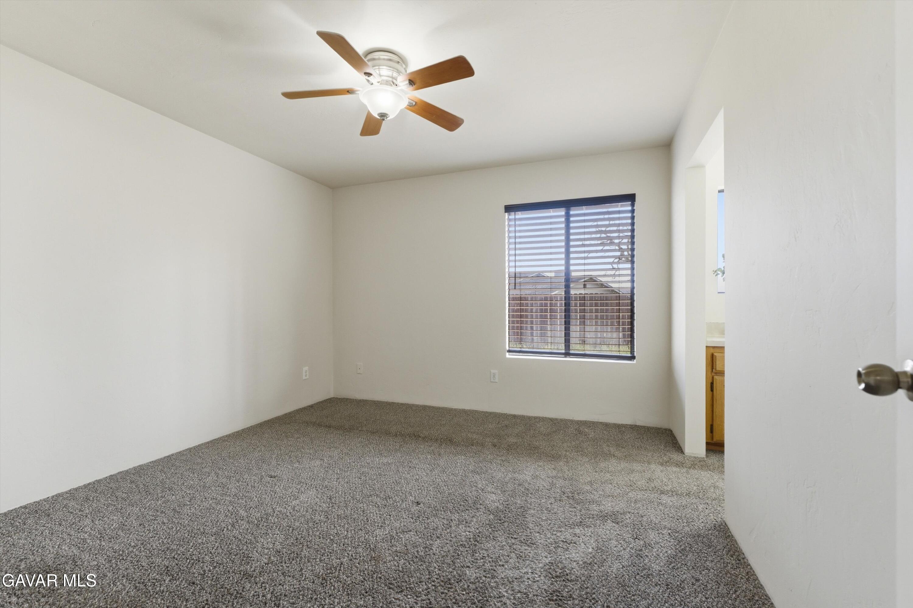 21410 Mission Street Tehachapi, CA 93561 - Photo 12 of 19 an empty room with a window and a ceiling fan