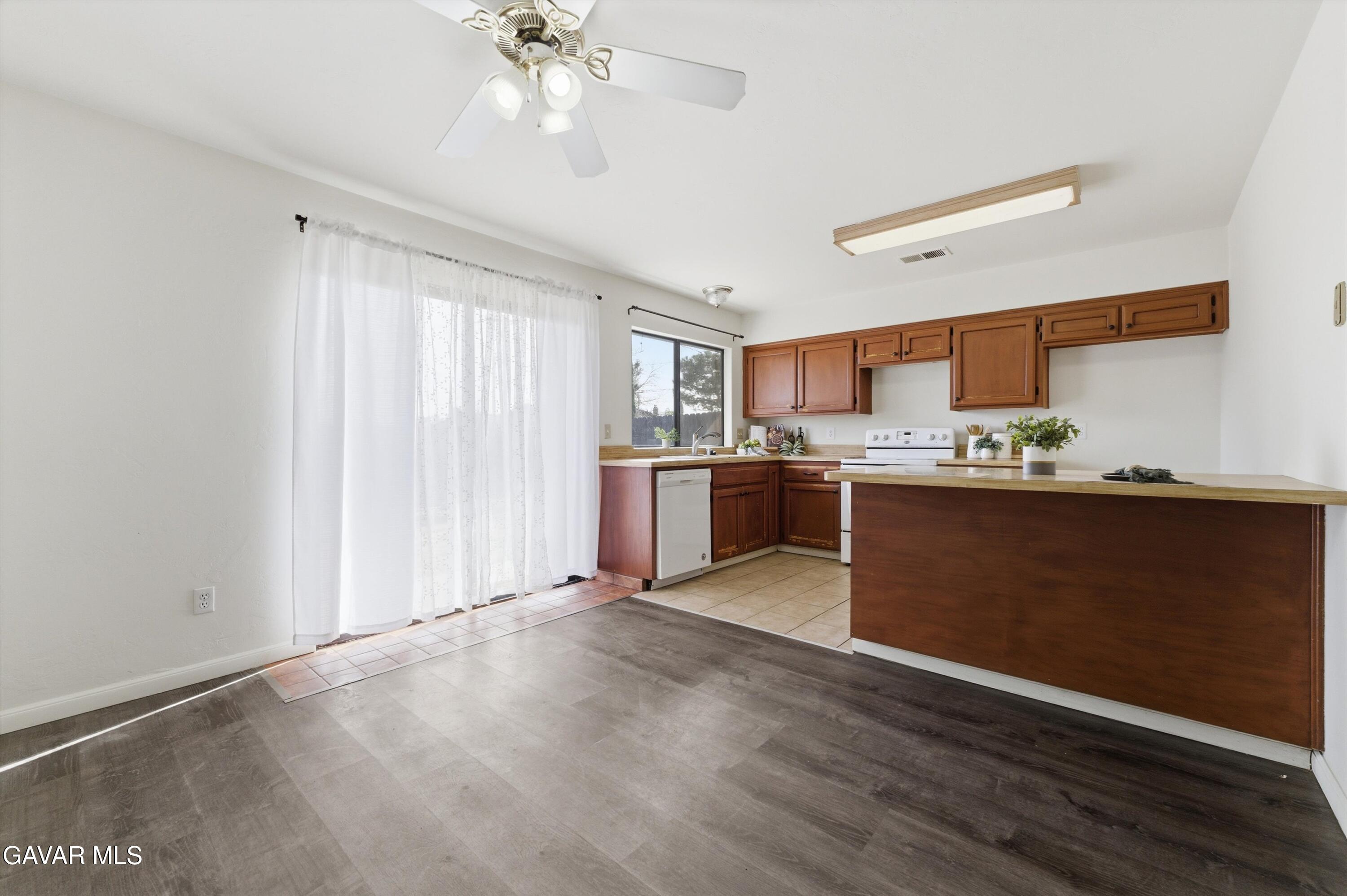 21410 Mission Street Tehachapi, CA 93561 - Photo 5 of 19 a kitchen with stainless steel appliances granite countertop a sink cabinets and wooden floor