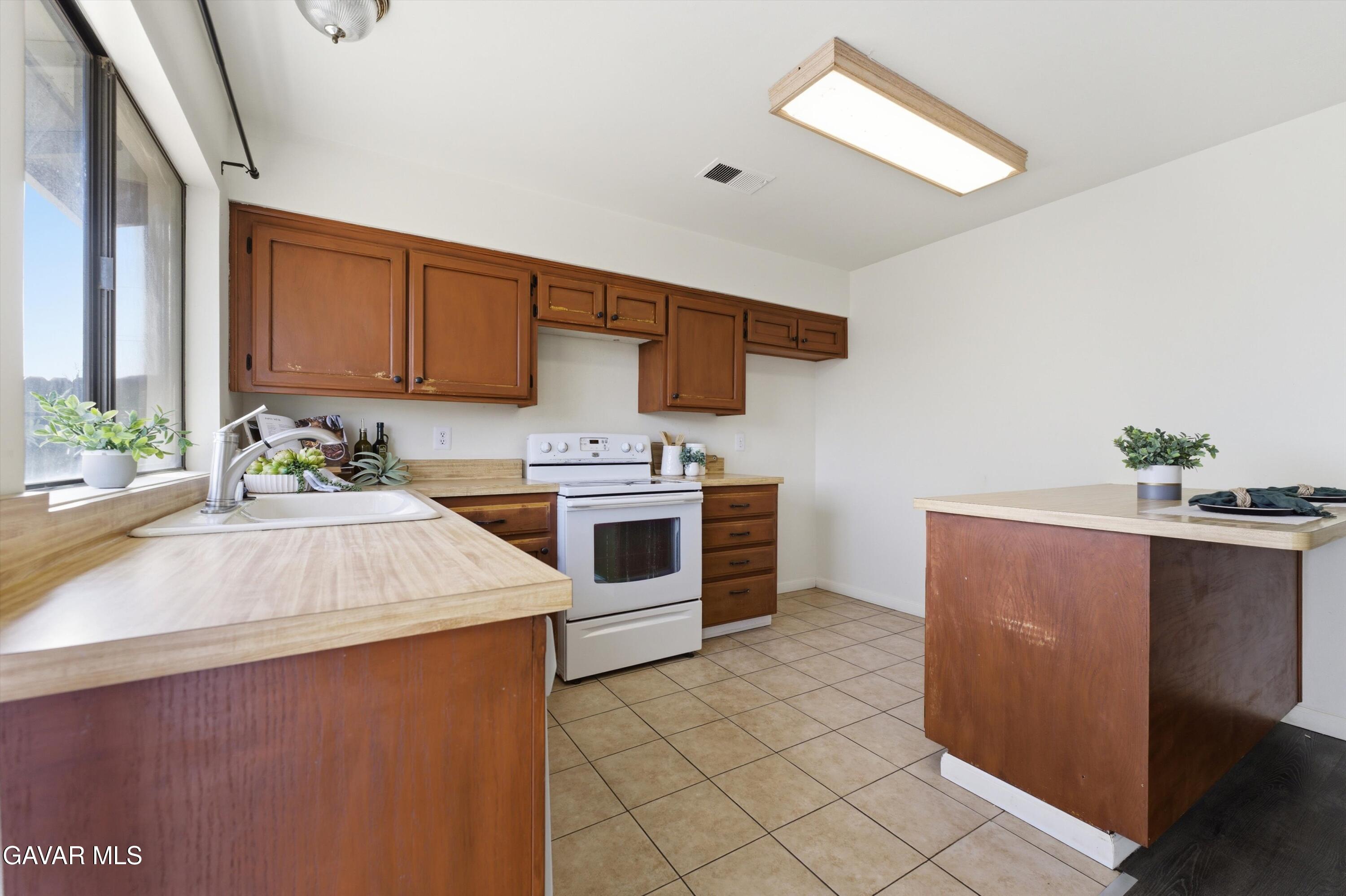21410 Mission Street Tehachapi, CA 93561 - Photo 6 of 19 a kitchen with granite countertop a sink cabinets and stainless steel appliances