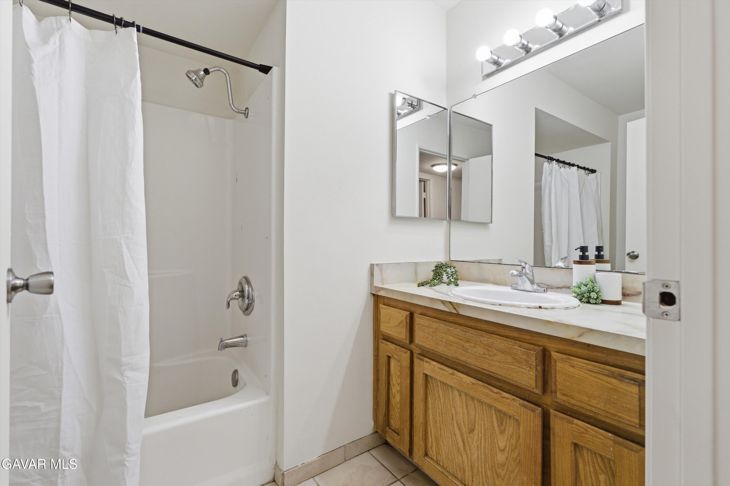 21410 Mission Street Tehachapi, CA 93561 - Photo 10 of 19 a bathroom with a granite countertop sink mirror and a bathtub