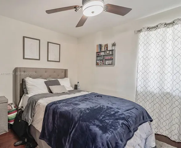 a bedroom with a bed and a painting on the wall