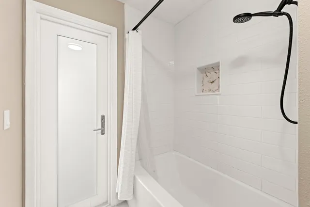 a bedroom with a bed and a flat tv screen on dresser