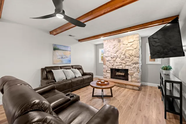 a living room with furniture a flat screen tv and a fireplace