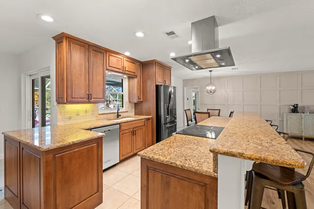 a kitchen with a table chairs refrigerator and cabinets