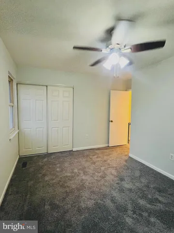 an empty room with a ceiling fan and a window