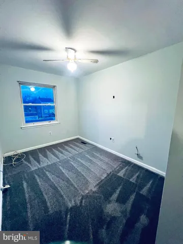 an empty room with a ceiling fan and window