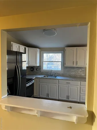 a kitchen with stainless steel appliances granite countertop a sink and a refrigerator