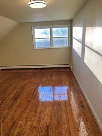a view of a room with wooden floors and window